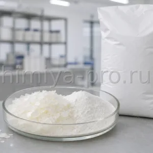 Белые чешуйки и порошок поливинилового спирта в стеклянной чаше — водорастворимый полимер для клеёв и керамики