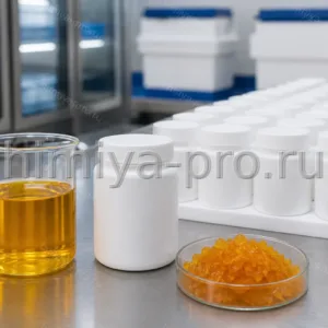 Жёлто-оранжевый концентрат ретинола ацетата в банках 1 кг и лабораторном стакане на упаковочном столе