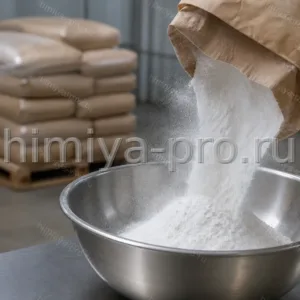 Белый сухой кукурузный крахмал, высыпаемый из бумажного мешка в стальную чашу на пищевом складе
