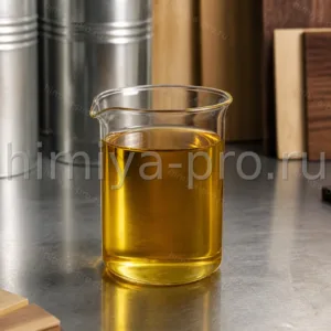 Янтарное рафинированное льняное масло в стакане на столе лакокрасочного цеха рядом со стальными бочками