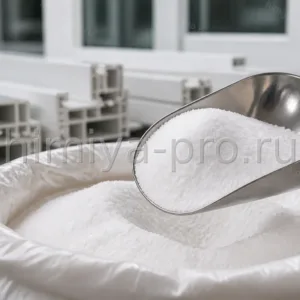 Белый сыпучий порошок суспензионной смолы ПВХ в стальном совке у оконных профилей на участке промышленной приёмки.