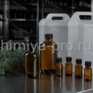 Оранжево-жёлтое эфирное масло руты в герметичных янтарных флаконах рядом с травой руты душистой