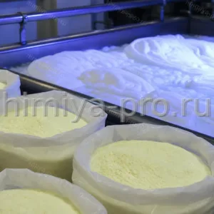 Светло-жёлтый порошок оптического отбеливателя и хлопковое полотно с голубоватой белизной в текстильной ванне