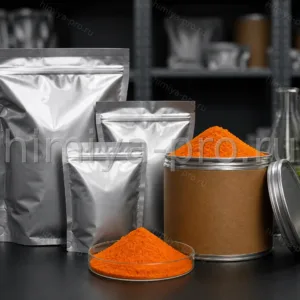 Оранжевый порошок растительного экстракта бета-каротина в алюминиевых пакетах на тёмном складе сырья