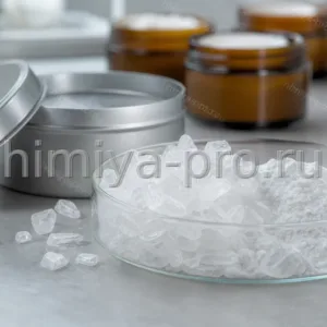 Белые восковидные кристаллы камфоры в стеклянной чашке и металлической банке на лабораторном столе