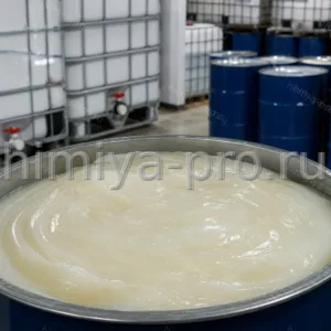 Вязкая белая паста лауретсульфата натрия около 70% в промышленной бочке рядом с IBC-контейнерами на складе ПАВ