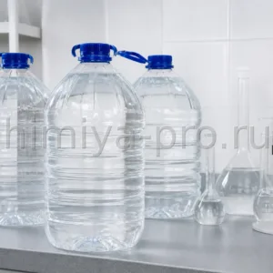 Прозрачные ПЭТ-бутыли дистиллированной воды по 5 литров на лабораторном столе для растворов, промывки и аккумуляторов