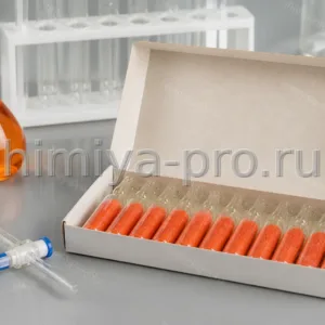 Ампулы стандарт-титра двухромовокислого калия 0,1 Н с оранжево-красными кристаллами в коробке на лабораторном столе.
