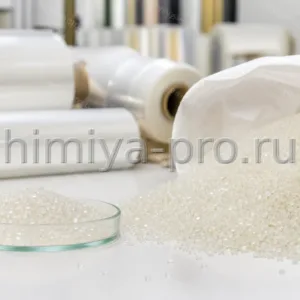 Натуральные гранулы полипропилена у открытого мешка 25 кг на фоне рулонов гибкой многослойной упаковочной плёнки