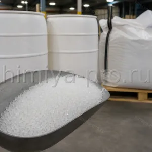 Выдувные гранулы HD20532 LB на совке перед промышленными бочками и биг-бэгом сырья на паллете