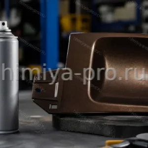 Промышленный аэрозоль спрей-краски 6960/1829 на ремонтном столе рядом с панелью бронзово-коричневой эмали
