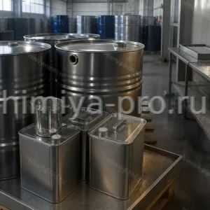 Металлические бочки и канистры с техническим ацетоном на паллете в цехе растворителей, мерный кувшин с бесцветной жидкостью.