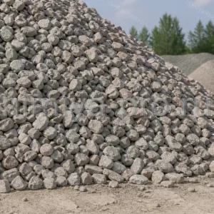 Остроугольный серый щебень из горных пород насыпью в кузове самосвала на площадке инертных материалов